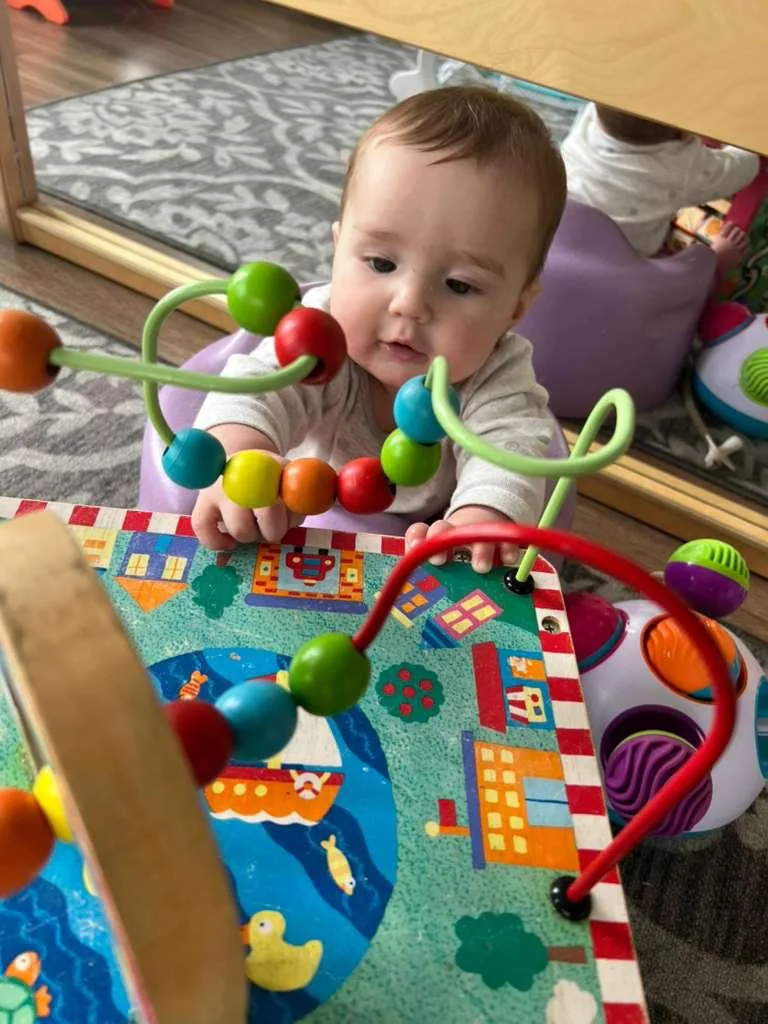 Infant student exploring a bead maze at Providence Montessori Academy