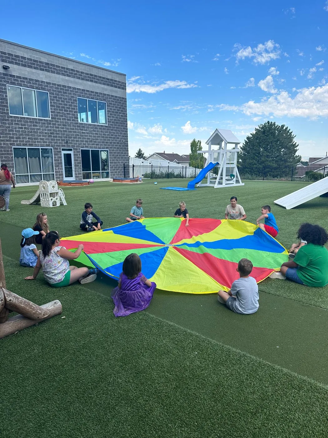Students participating in parachute play outdoors